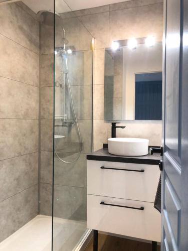 une salle de bain avec un lavabo et une douche dans l'établissement Ravissant Appartement au Domaine du Golf, à Lacanau