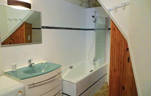 a bathroom with a sink and a tub and a mirror at Nice Home In Chinon With 2 Bedrooms And Wifi in Chinon
