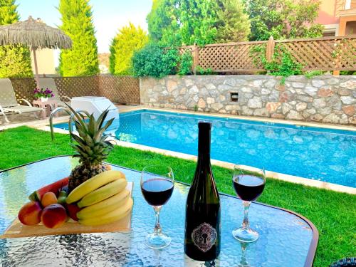 una mesa con una botella de vino y un bol de fruta en Villa Katerina en Stalida