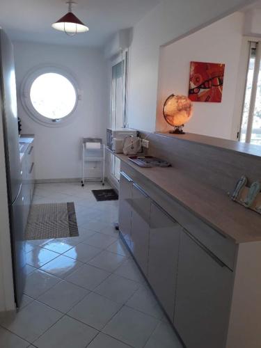 une cuisine avec un comptoir et une fenêtre dans l'établissement Joli T3 lumineux confortable et idéale situation, à Cavalaire-sur-Mer