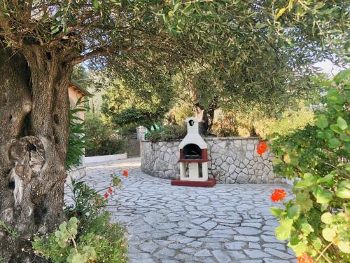 a stone walkway with a fireplace in a garden at Gran Domenica Villa Corfu, Private Pool, Sea View, Garden in Nisakion