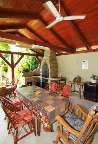 a patio with a table and chairs and a stone fireplace at Šumski raj in Subotica