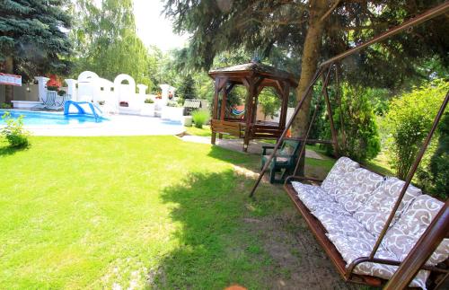 a porch swing in a yard with a playground at Šumski raj in Subotica