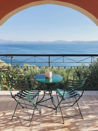 a table and chairs on a balcony with the ocean at Gran Domenica Villa Corfu, Private Pool, Sea View, Garden in Nisaki