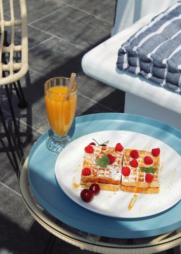 a plate with a piece of cake and a glass of orange juice at Aeron Suites in Éxo Goniá