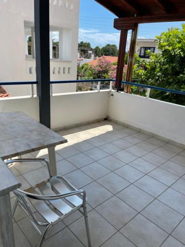 a patio with a table and chairs on a balcony at Artemis Hotel Apartments in Keramotí