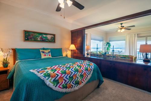 een slaapkamer met een bed met een groen dekbed en een raam bij Hanalei Colony Resort F3 in Hanalei