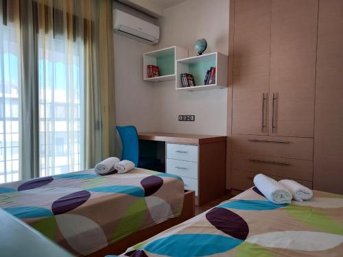 a bedroom with two beds and a desk and a window at Luxury Summer Escape in Rhodes in Rhodes Town