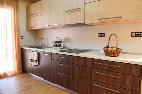 a kitchen with wooden cabinets and a basket of fruit on the counter at Luxury Summer Escape in Rhodes in Rhodes Town