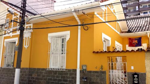 a yellow house with white windows and stairs at Casa em Botafogo (Rio de Janeiro) in Rio de Janeiro