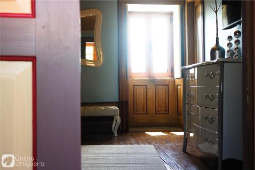 a room with a dresser and a mirror and a door at Quinta da Urtigueira in Felgueiras