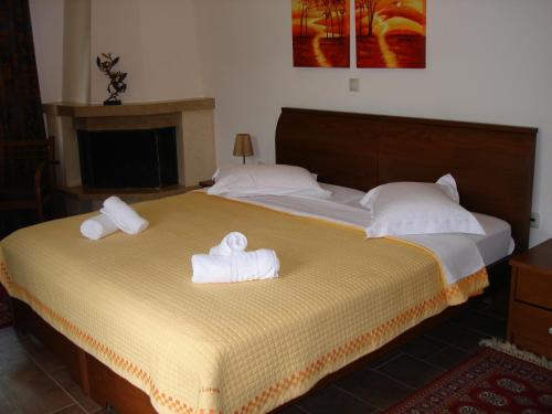 a bedroom with a large bed with towels on it at Armonia Hotel in Kato Loutraki