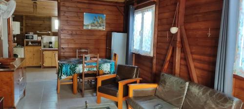 a living room with a table and a couch at Wooden Kaz, Meublé de tourisme 2 étoiles in Le Moule