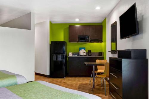 a small room with a kitchen and a table with chairs at Studio 6-Portland, OR in Parkrose