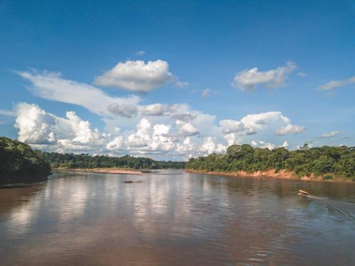 a river with two boats in the water at Wasai Tambopata Lodge in Tambopata