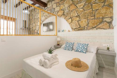 ein Schlafzimmer mit einem Bett mit Hut darauf in der Unterkunft apartamento loft a 50 metros de la playa y paseo maritimo in El Campello