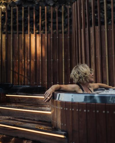 a man sitting in a bath tub in a wooden at Elk at Falls in Falls Creek
