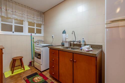 a kitchen with a sink and a refrigerator at Rosa Edifício Saint Moritz in Gramado