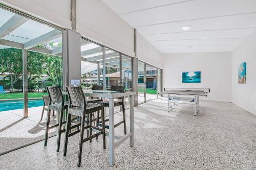 a dining room with a table and chairs and a piano at Beaches on Lammermoor Apartments in Yeppoon