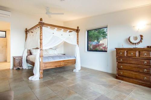 1 dormitorio con cama con dosel y vestidor en Bali in Mornington Oceanview Villa, en Arthurs Seat