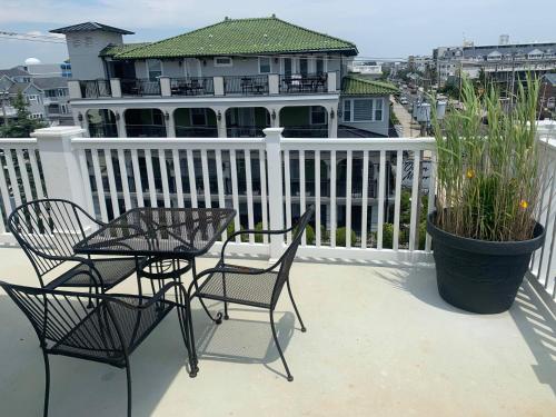 a balcony with chairs and a table and a house at Ocean Manor 1100 Inn in Ocean City