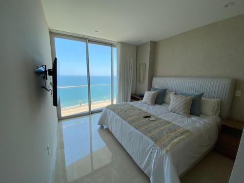 a bedroom with a bed with a view of the ocean at Camino al mar 2303 vista al mar in Mazatlán