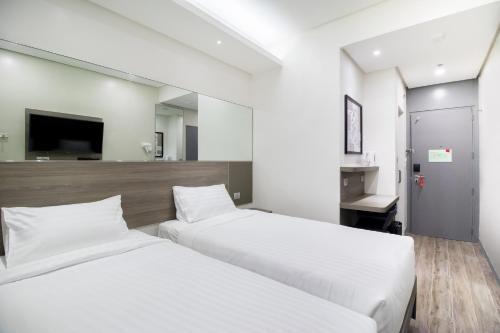 a hotel room with two beds and a tv at Red Planet BGC The Fort in Manila