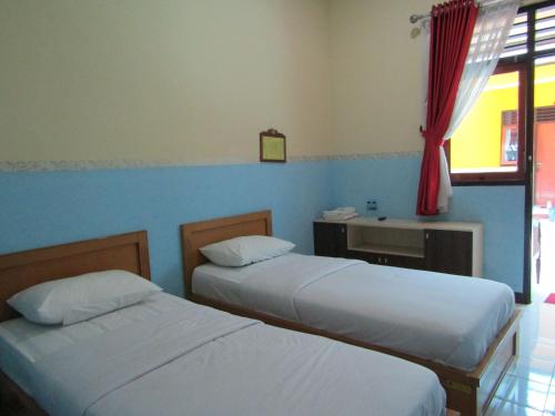 - une chambre avec 2 lits, un lavabo et une fenêtre dans l'établissement Hotel BIP Tawangmangu, à Solo