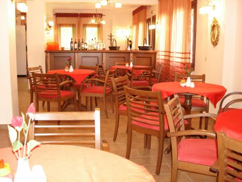 a dining room with red tables and chairs at Armonia Hotel in Kato Loutraki