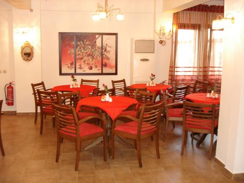 a dining room with red tables and chairs at Armonia Hotel in Kato Loutraki