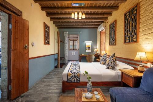 a bedroom with a bed and a couch and a table at Yangshuo Secret Garden in Yangshuo