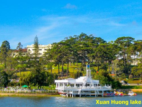a white boat on the water in a park at Jolie House in Da Lat