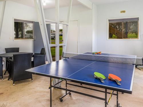 a ping pong table with two tennis rackets on it at The Boat Ramp Getaway in Corinella