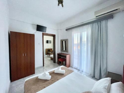 a bedroom with two white towels on a bed at Hotel Pighi in Kriopigi