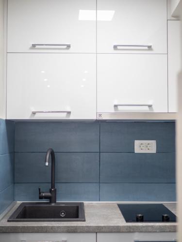 a kitchen with a sink and white cabinets at Luxury Boutique Studio in Budva
