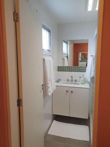 a white bathroom with a sink and a mirror at Pouso Mantiqueira in Cunha