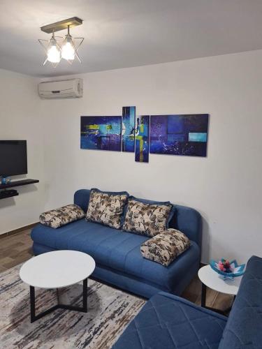 a living room with a blue couch and a table at Apartmani Vanja in Baošići