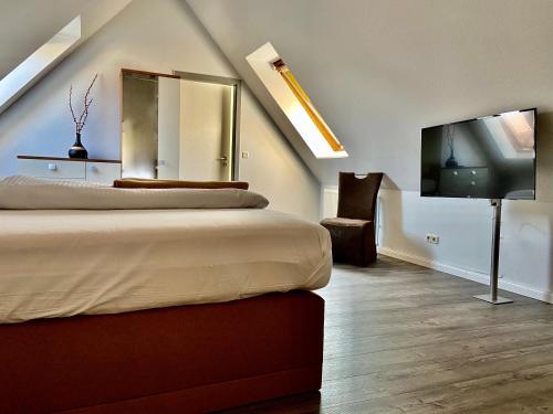 a bedroom with two beds and a flat screen tv at Residenz Hotel Neu Wulmstorf in Neu Wulmstorf