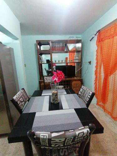 a dining room table with a vase of flowers on it at DEPARTAMENTO MUY CERCANO AL AEROPUERTO CD. MEX T2 in Mexico City