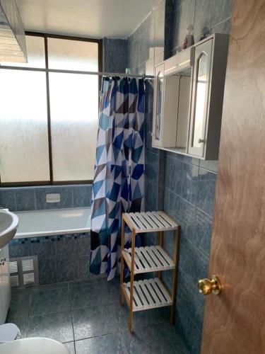 a bathroom with a blue and white shower curtain at Departamento Amoblado Talca in Antofagasta