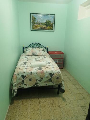 a bedroom with a bed with a floral comforter at DEPARTAMENTO MUY CERCANO AL AEROPUERTO CD. MEX T2 in Mexico City