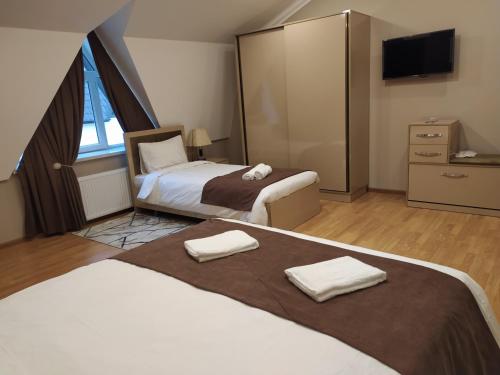 a hotel room with two beds and a tv at Gold Hotel Quba in Quba