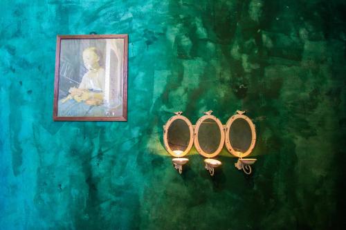 two mirrors on a wall with a picture of a baby at Vila Terrasse in Košice