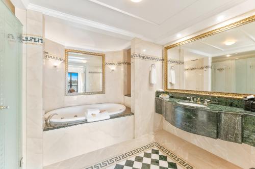 a bathroom with a tub and a large mirror at Imperial Hotel Gold Coast in Gold Coast