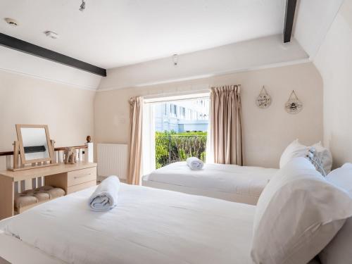2 camas en una habitación con ventana en 3bed Apartment 5mins walk from beach and Southsea, en Bournemouth