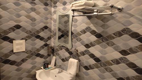 a bathroom with a sink and a mirror at Krishnabalram wellness & Ayurveda centre in Rishīkesh