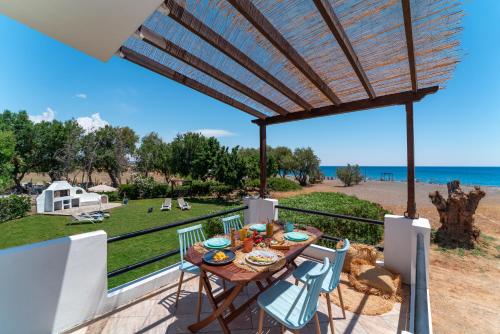 patio ze stołem i krzesłami oraz widokiem na ocean w obiekcie Eco Beach And Magic Garden Hotel w mieście Jenadi