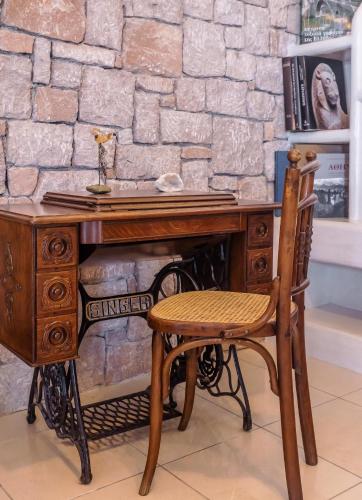 a wooden desk with a chair next to a stone wall at Tania Milos in Pollonia