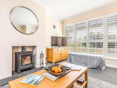 a living room with a table and a fireplace at 3 bedroom Cottage in the heart of beautiful Bosham - Pass the Keys in Chichester