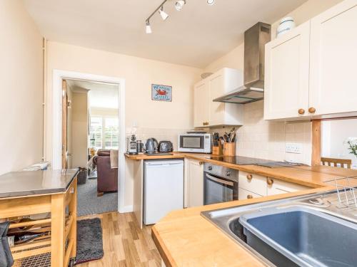 a kitchen with a sink and a counter top at Pass the Keys 3 bedroom Cottage in the heart of beautiful Bosham in Chichester